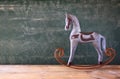 Vintage rocking horse next to fabric hearts hanging on the rope on wooden floor. retro filtered image Royalty Free Stock Photo