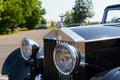 A vintage Rolls Royce Phantom. Front view of the bumper, hood, grille and headlights.