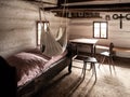 Vintage room with bed, table and chairs in old rural house. Sepia style image Royalty Free Stock Photo