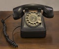 A vintage rotary dial telephone on an old wooden table Royalty Free Stock Photo