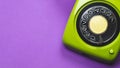 Vintage rotary phone. classic green telephone with round dial. isolated on purple background. old communication technology Royalty Free Stock Photo