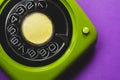 Vintage rotary phone. classic green telephone with round dial on purple background. old communication technology Royalty Free Stock Photo