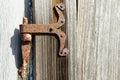 Vintage rusted metal door hinge over the weathered wooden wall. Royalty Free Stock Photo