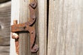 Vintage rusted metal door hinge over the weathered wooden wall. Royalty Free Stock Photo