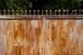 A vintage rusted steel gate on permanent closing and becoming fence. The steel gate has some palm mark on the surface. The palm ar