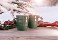 Vintage rustic card with green porcelain cups of tea on white wooden table decorated with snowy fir tree and red Royalty Free Stock Photo