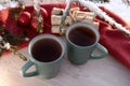 Vintage rustic card with green porcelain cups of tea on white wooden table decorated with snowy fir tree and red Royalty Free Stock Photo