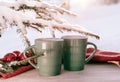 Vintage rustic card with green porcelain cups of tea on white wooden table decorated with snowy fir tree and red Royalty Free Stock Photo