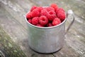 Vintage rustic mug full of raspberry berries.