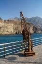 A vintage Rusty heavy duty chain fitted hand derrick, crane in small old dock side, used to unload small ships and boats