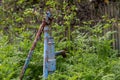 Vintage rusty water fountain hand pump in russian village. Abandoned water wellhead Royalty Free Stock Photo