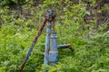 Vintage rusty water fountain hand pump in russian village. Abandoned water wellhead Royalty Free Stock Photo