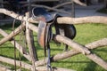 Vintage saddle on rural fence. Ranch scene