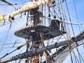 Vintage sailing ship mast ropes and tackle, Tall ship rigging mast detail, blue sky background