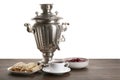 Vintage samovar, cup of hot drink and snacks on wooden table against white background, space for text. Traditional Russian tea Royalty Free Stock Photo