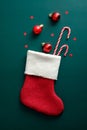 Vintage Santa stocking with candy canes, red balls, and decorations on green background