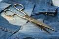Vintage sartorial scissors and torn denim blue scraps