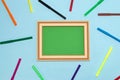 vintage school green board as copy space on a pastel blue background with colorful markers, back to school Royalty Free Stock Photo