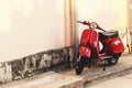 Vintage scooter parked near a building wall