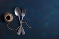 Vintage set of spoon and fork connected linen thread on a blue background. Time bound fork and spoon. Copy space