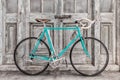 Vintage seventies light blue racing bicycle in front of old black and white wooden doors