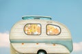 Vintage seventies white caravan in front of a blue sky with clouds