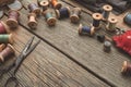 Vintage sewing items: scissors, thimbles, wooden spools of thread, cushion for including pins, needles. Top view. Copy space.