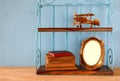 Vintage shelf with old wooden plane toy, books and blank photo frame Royalty Free Stock Photo