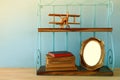 Vintage shelf with old wooden plane toy, books and blank photo frame Royalty Free Stock Photo