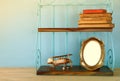 Vintage shelf with old wooden plane toy, books and blank photo frame Royalty Free Stock Photo