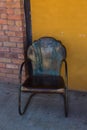 Vintage shell scalloped back dark metal patio armchair on sidewalk