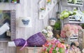 Vintage shop with colorful flowers. Selective focus on the violet flower bouquet on top of wooden shelf