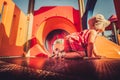 Vintage shot of baby profile crawling inside orange playground structure children point of view Royalty Free Stock Photo