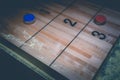 Vintage shuffle board game with red and blue disc on wooden shuffle table. Shuffleboard table game with selective focus.