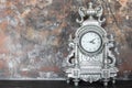 Vintage silver clock on the mantelpiece in the interior Royalty Free Stock Photo