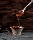 Vintage silver cup of liquid chocolate and spoon with flowing chocolate Royalty Free Stock Photo