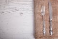 Vintage silver tableware knife and fork is on napkin, on an old Royalty Free Stock Photo