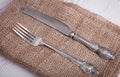 Vintage silver tableware knife and fork is on napkin, on an old Royalty Free Stock Photo