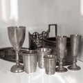 Vintage silverware dishes, glasses, cup holder, bowl, dish on a glass shelf in a white cabinet