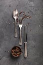Vintage Silverware and Peppercorns on Dark Stone Background Royalty Free Stock Photo