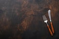 Vintage silverware. Rustic vintage set of wooden spoon and fork on black wooden background. Empty dishes. Top view. Mock up Royalty Free Stock Photo