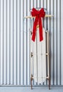 Vintage sled decorated with a red Christmas bow leaning against a wall