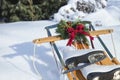 Vintage sled in snow with wreath and red bow and white skates