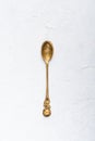 Vintage small brass spoon on white table background top view