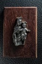 Vintage small idol of Mary and child Jesus on a wooden plank.