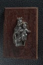 Vintage small idol of Mary and child Jesus on a wooden plank.