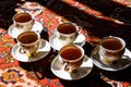 Vintage soviet porcelain cups of tea with saucers on turkish carpet, traditional tea ceremony, sunlight Royalty Free Stock Photo