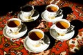 Vintage soviet porcelain cups of tea with saucers on turkish carpet, traditional tea ceremony, sunlight Royalty Free Stock Photo