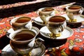 Vintage soviet porcelain cups of tea with saucers on turkish carpet, traditional tea ceremony, sunlight Royalty Free Stock Photo