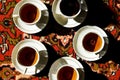 Vintage soviet porcelain cups of tea with saucers on turkish carpet, traditional tea ceremony, sunlight Royalty Free Stock Photo